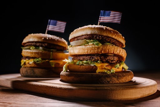 a two burgers with small flags on top